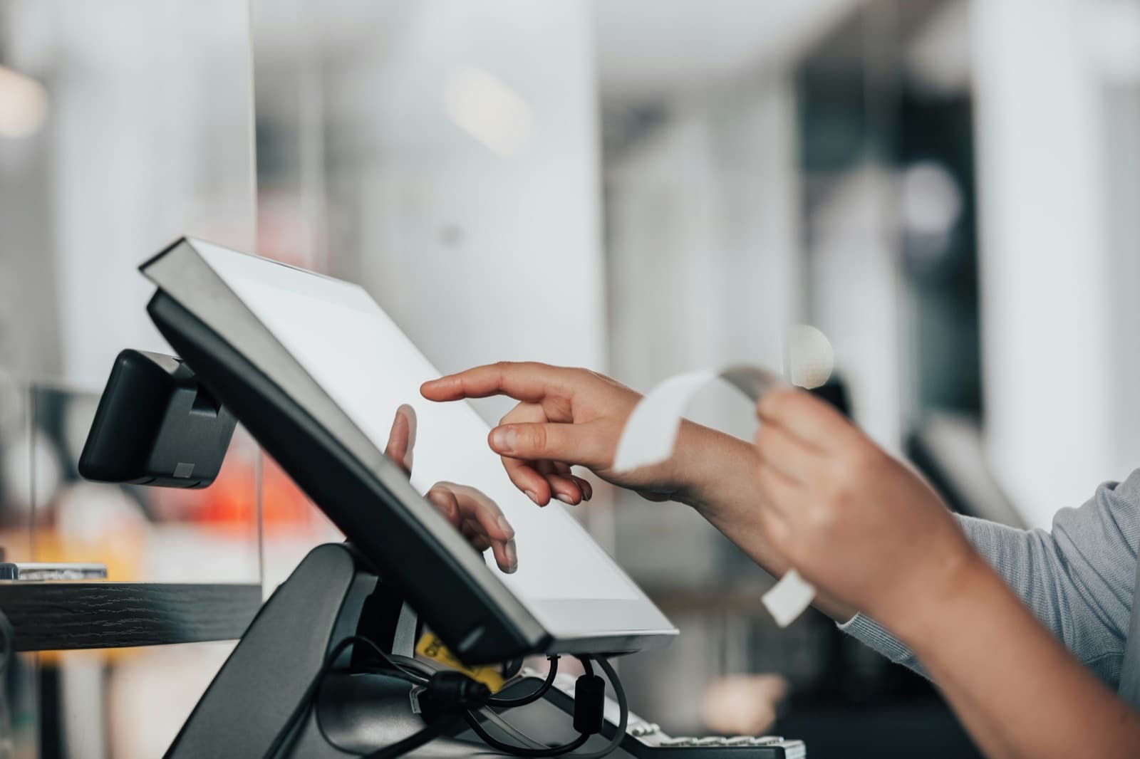Cobro en el mostrador: una empleada opera la terminal y entrega el ticket
